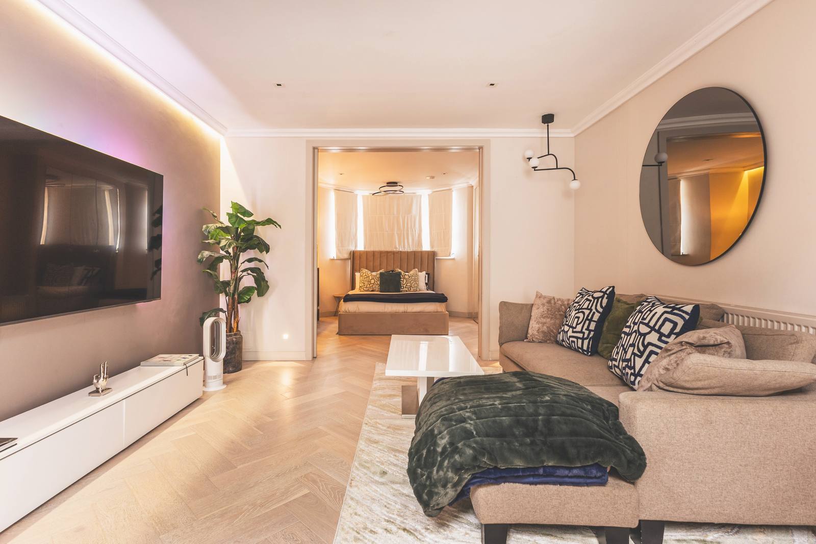 The living room with corner sofa, looking through to bedroom one