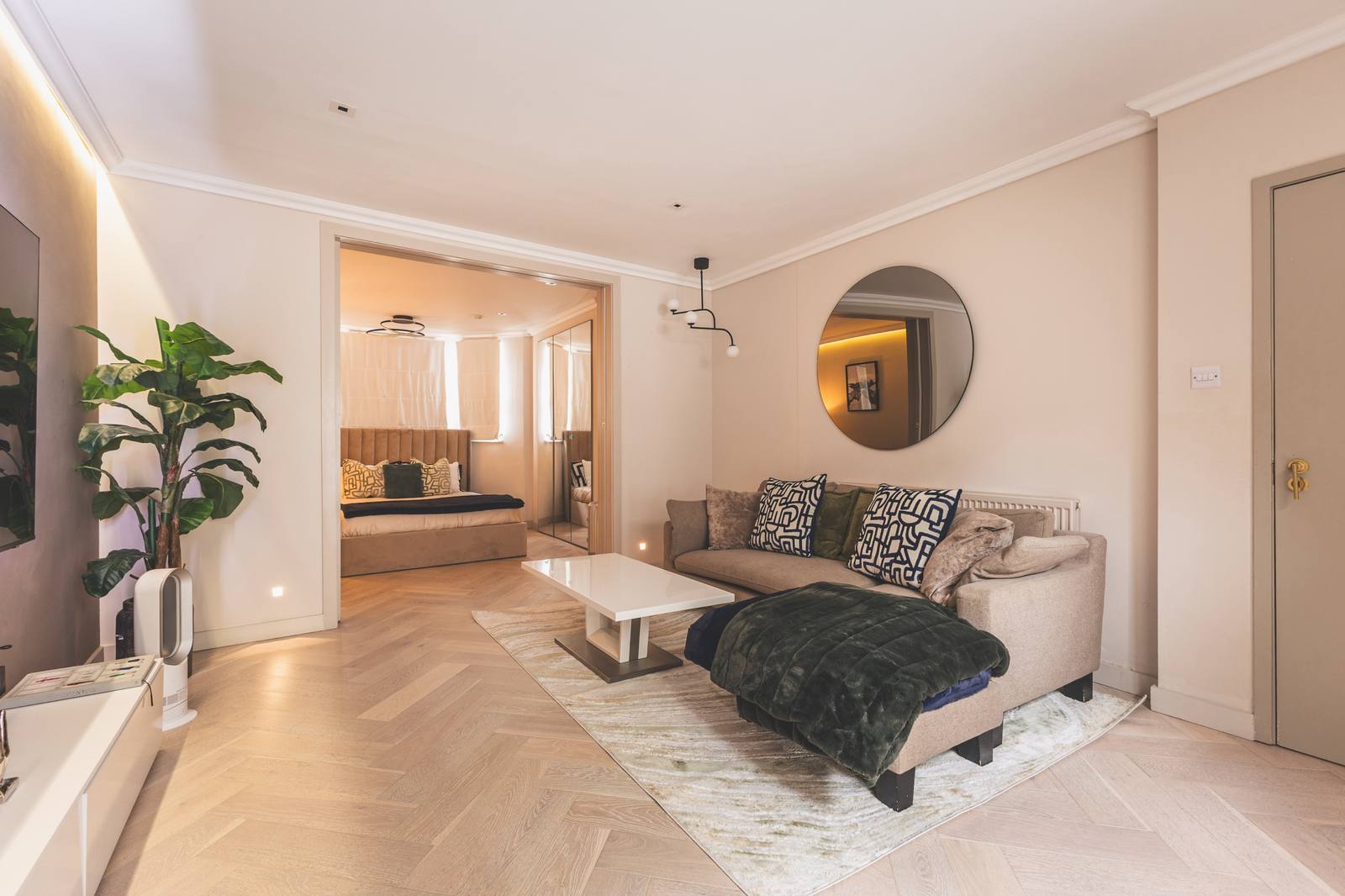 The living room with herringbone floor, corner sofa and plants